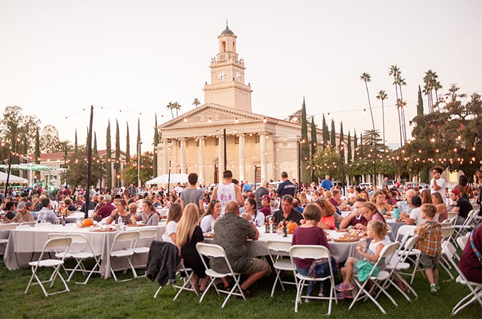 People gather on the Quad lawn during twilight at the University of Redlands during Homecoming weekend.