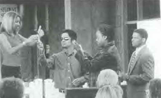 A group of people stand for a presentation in front of a building, black and white photo