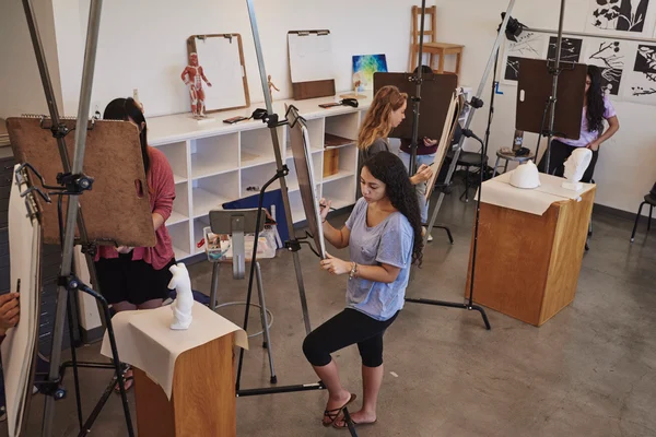 Students work on easels in an art studio