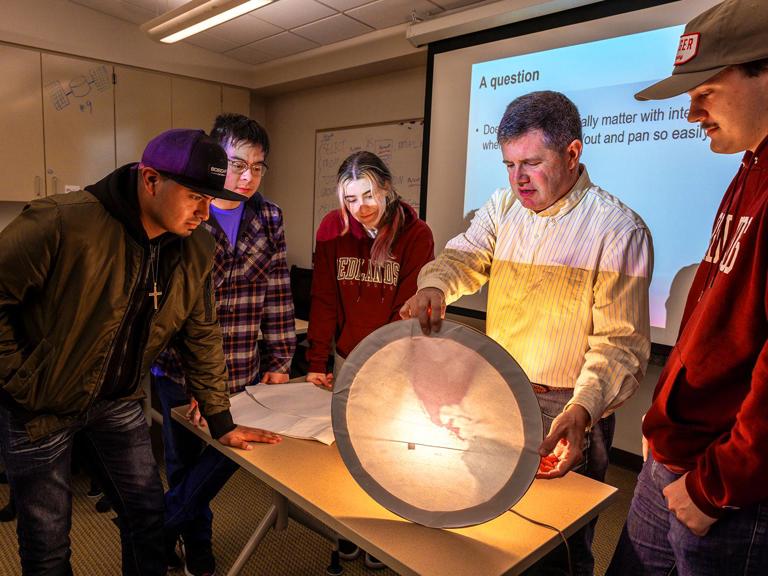 GIS Professor teaching students about light and maps.